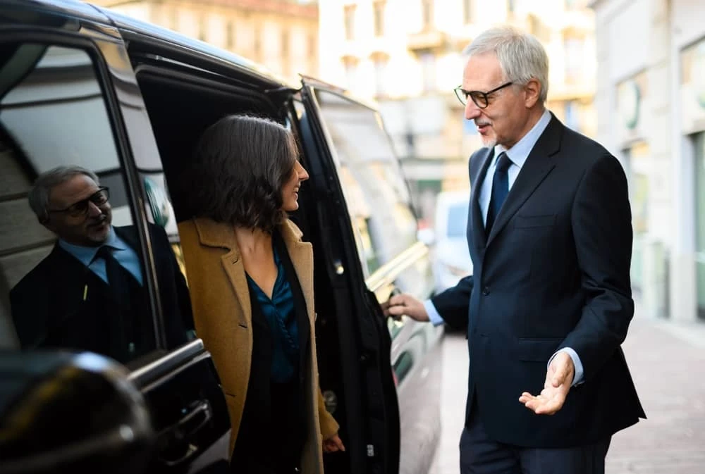 un chauffeur et une cliente sortant d'une voiture d'Azur Limousines