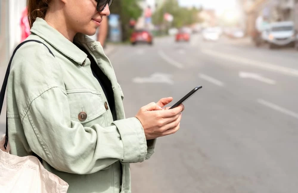 femme en train de commande un taxi chez PTS depuis son smartphone