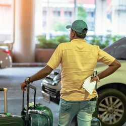 client attendant un taxi à la sortie d'un aéroport à l'étranger